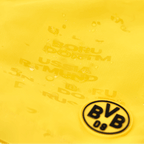 一款黄色多特蒙德（BVB）儿童泳裤的特写，上面印有“BVB 09”标志，并具有防泼水表面。