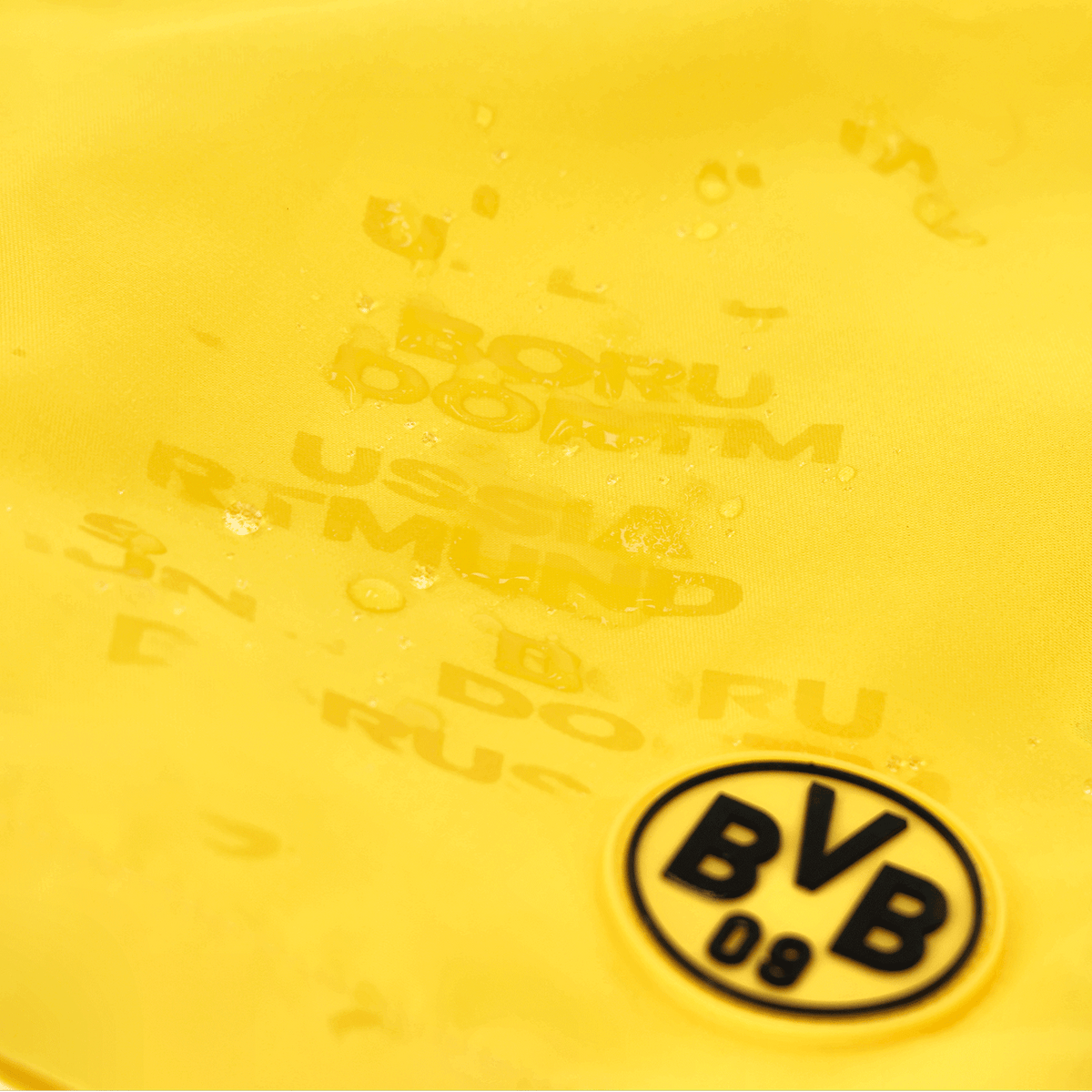 Yellow men's swim trunks featuring the BVB logo and "Borussia Dortmund" lettering, decorated with water droplets.