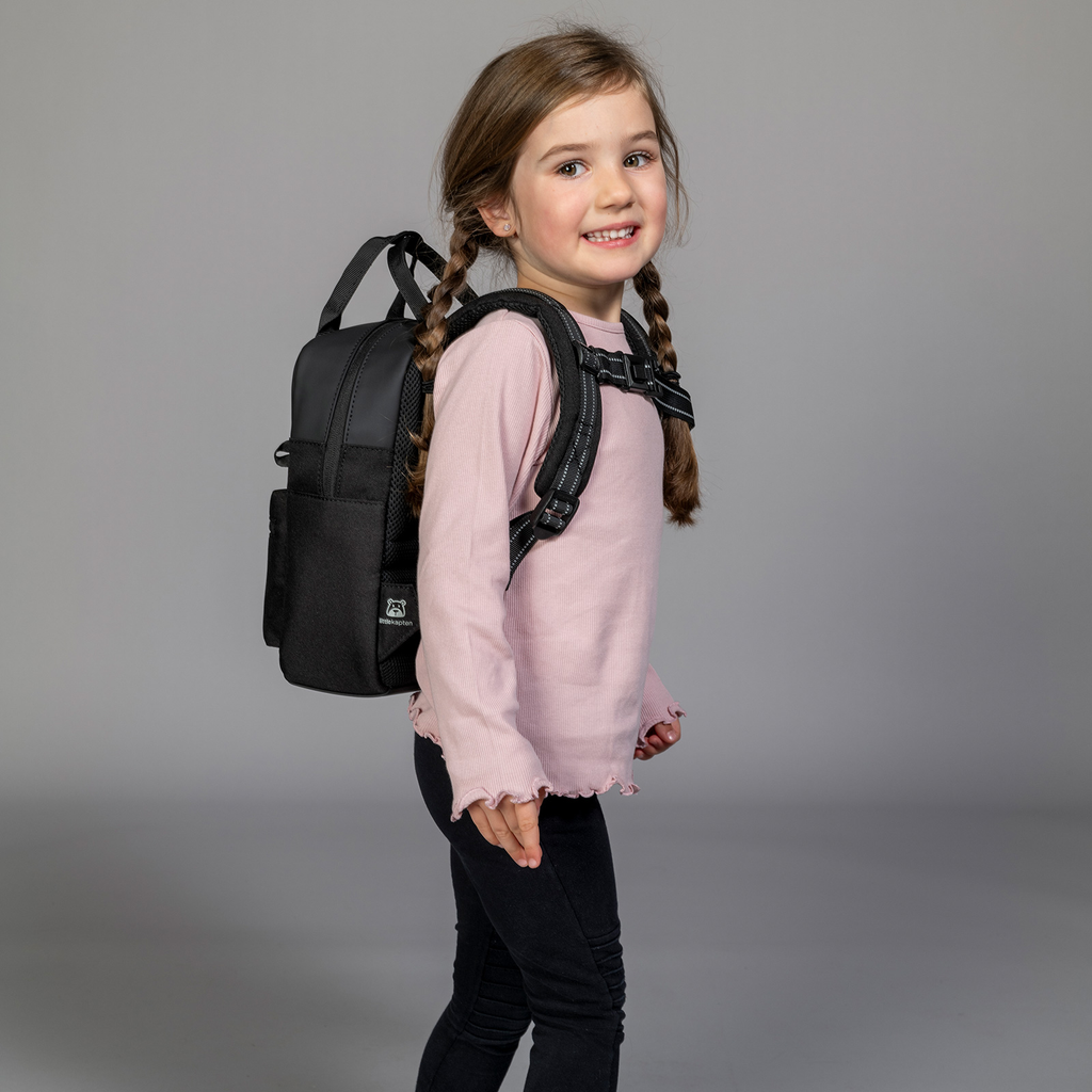 Ein Kind trägt den BVB X Kapten & Son Bergen Kids Rucksack in Schwarz. Der Rucksack ist funktional und stilvoll, ideal für junge Fans von Borussia Dortmund.