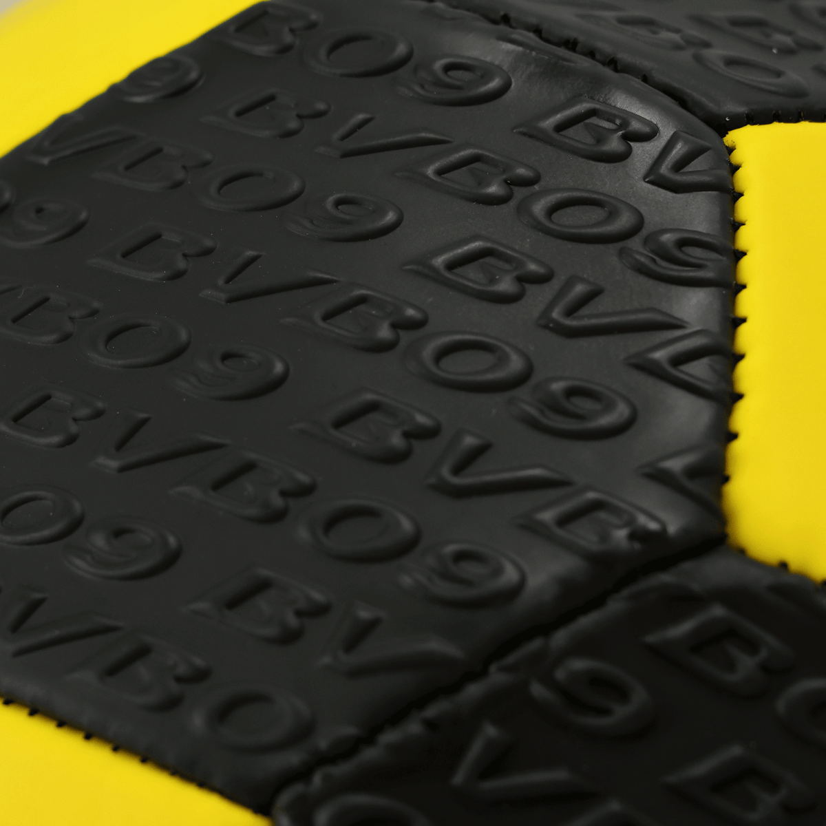 Close-up view of a BVB soccer ball with an embossed relief pattern in black and yellow.