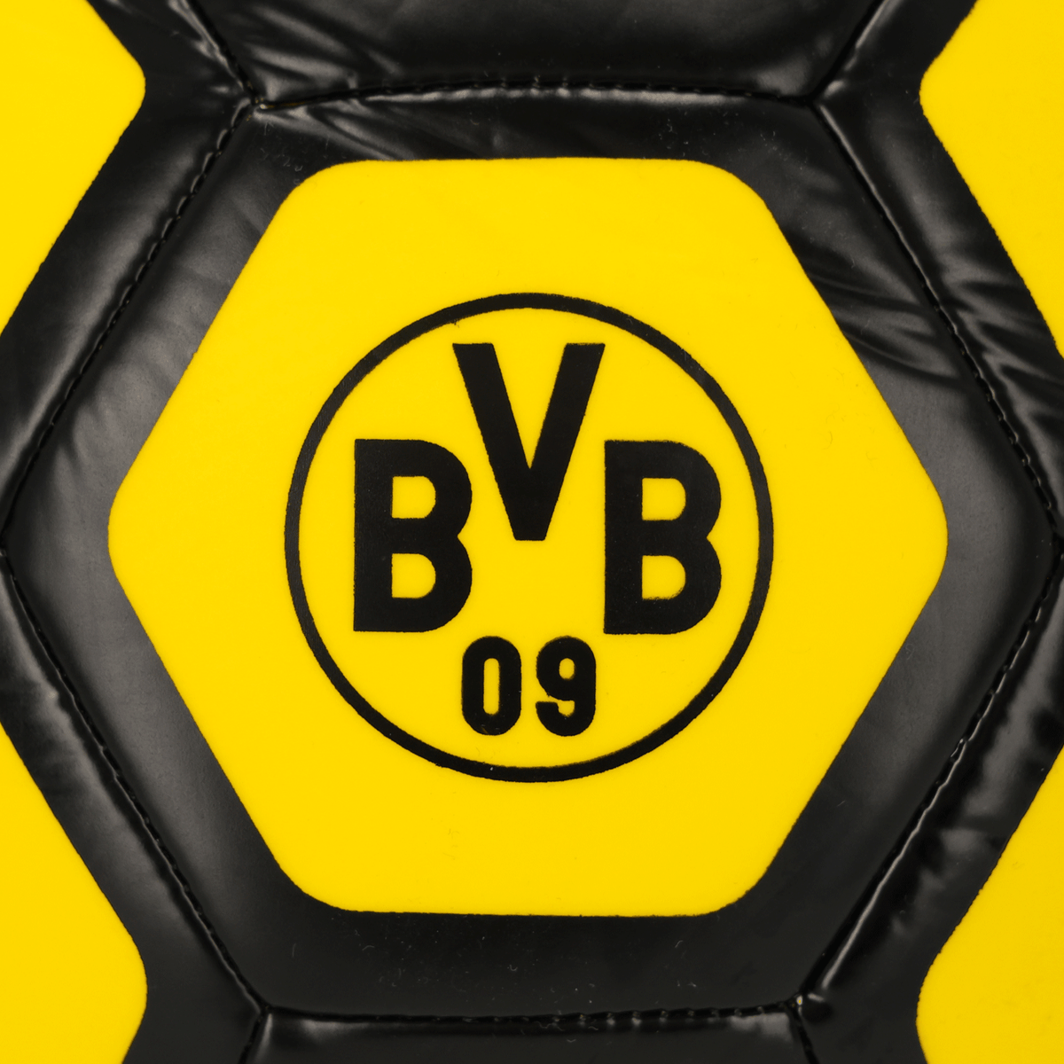 一张黑色和黄色相间的多特蒙德（BVB）公平贸易5号足球的特写照片，球上印有BVB队徽。