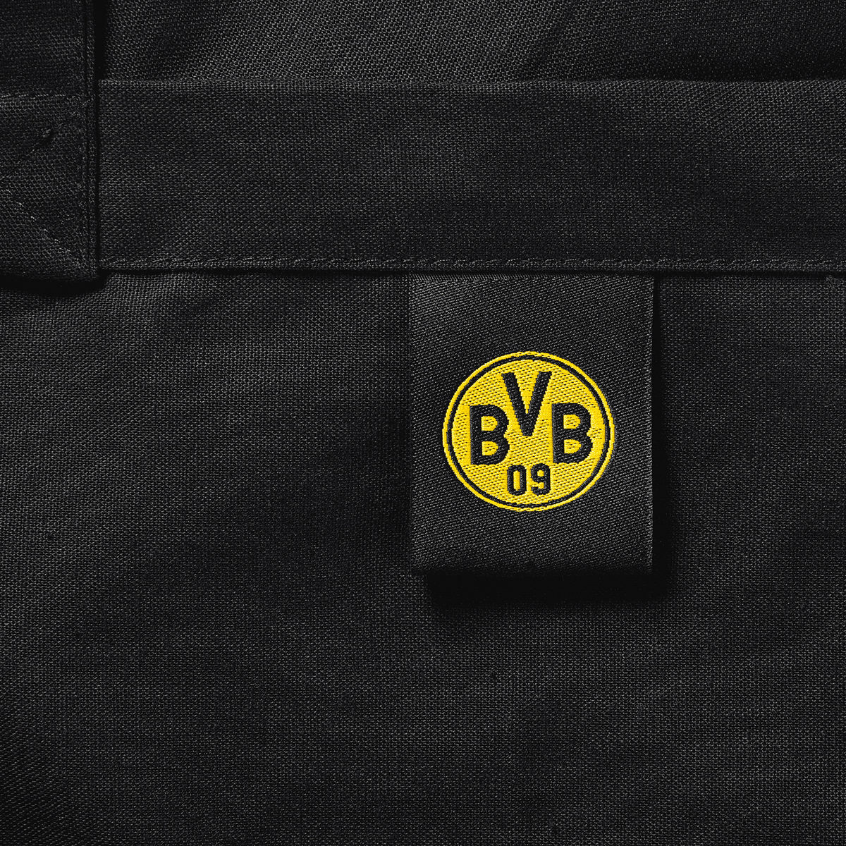 Sac en coton noir avec le logo jaune du BVB cousu dessus, idéal pour les supporters du Borussia Dortmund.