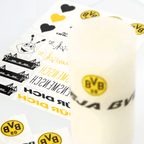 Papel decorativo DIY para velas del BVB en negro y amarillo con diversos motivos, como el logotipo del BVB, corazones, el estadio y EMMA, ideal para personalizar velas para los aficionados.