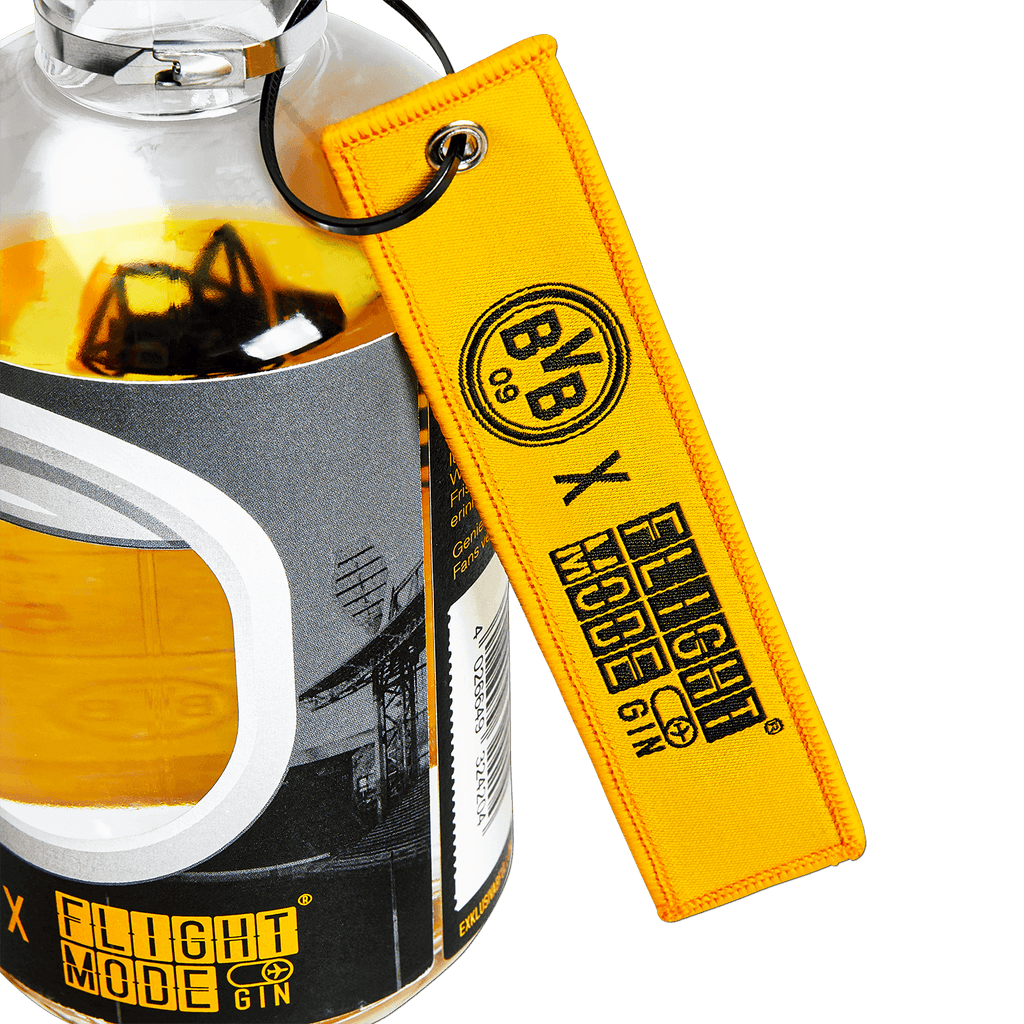 Una botella de ginebra BVB Flight Mode con un llavero amarillo y un diseño del estadio, disponible en exclusiva con motivo del aniversario del estadio.