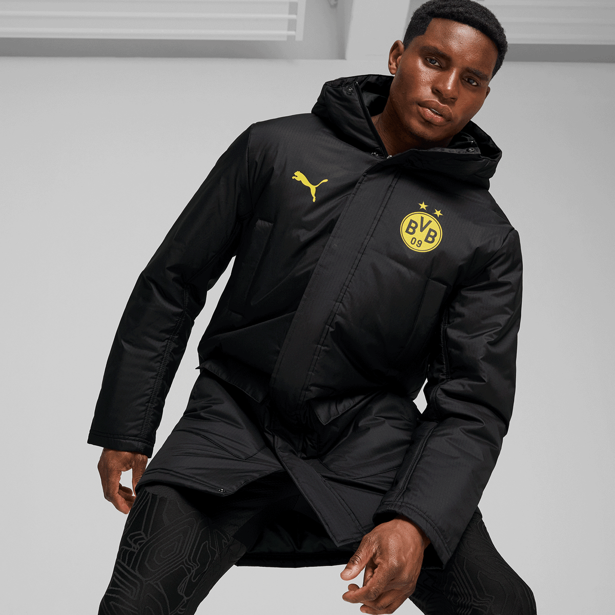 Veste d'hiver noir et jaune du BVB issue de la collection 24/25, ornée de l'emblème du BVB et du logo PUMA, idéale pour les fans de football.