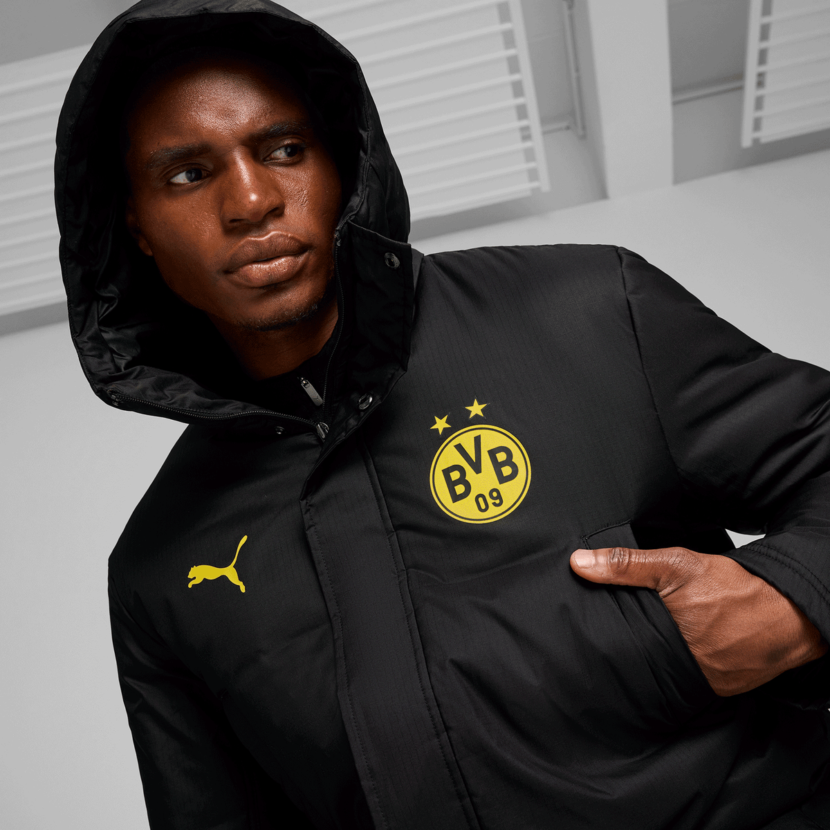 Giacca invernale nera del BVB della stagione 24/25 con cappuccio, due loghi (BVB e PUMA) e un design sportivo, ideale per le giornate fredde.