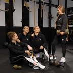 Women in the BVB x PUMA Gym collection, wearing comfortable black hoodies and workout leggings, posing at the gym.
