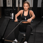 Black BVB x Puma Gym Cloudspun Tights for Women, worn by a woman while working out on a rowing machine at the gym.