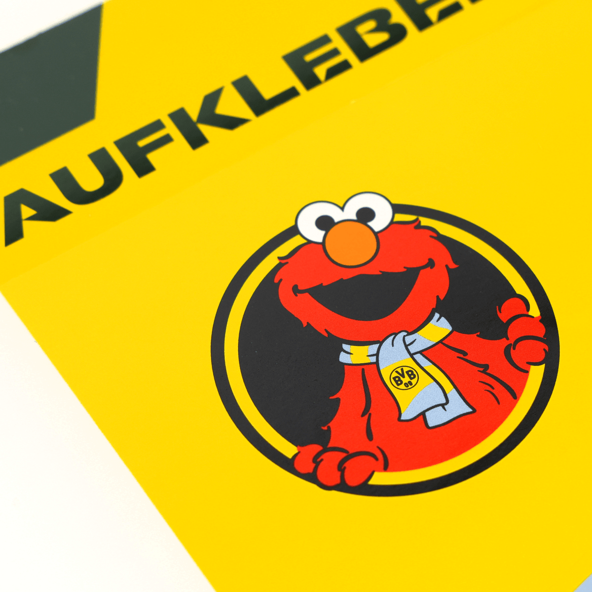 Carte à autocollants du BVB représentant Elmo, le personnage de « Sesame Street », sur fond jaune, ornée d'une écharpe du BVB et du logo du BVB. Un article idéal pour les supporters du BVB.