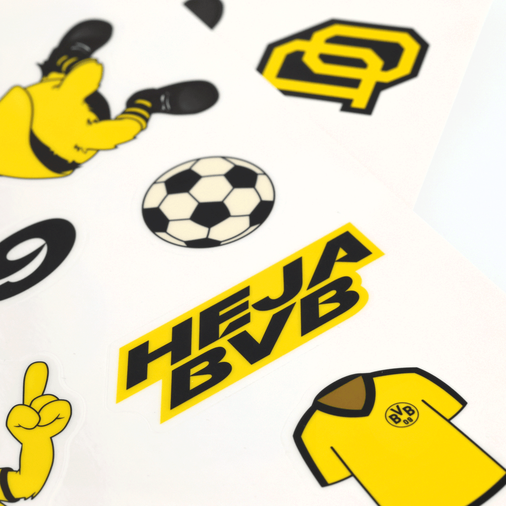 サッカー、HEJA BVBの文字、ユニフォーム、BVBのロゴなど、さまざまな黒と黄色のモチーフをあしらったBVBのウィンドウステッカー。ボルシア・ドルトムントのファンにとって定番のグッズです。