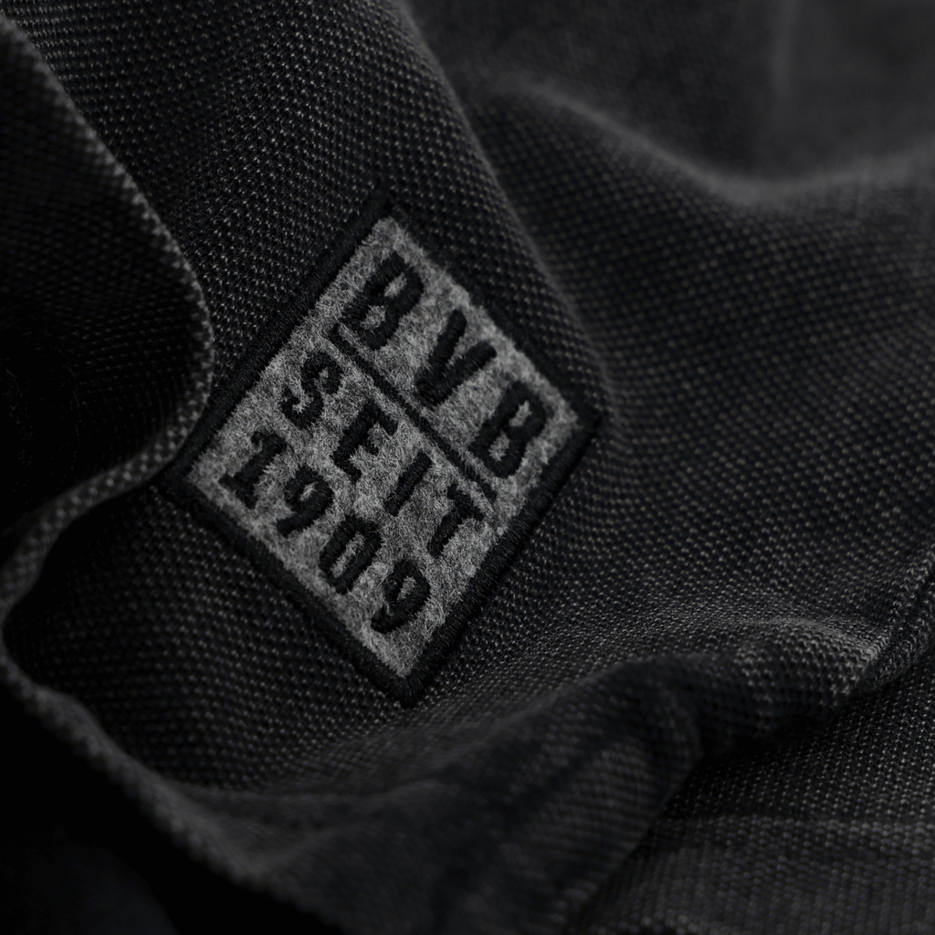 Nahaufnahme eines schwarzen Stoffes mit einem BVB-Logo und der Aufschrift 'BVB SEIT 1909'.
