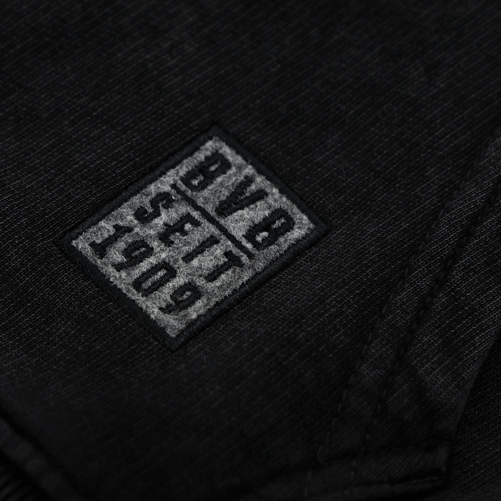 Detailaufnahme des BVB Elements Hoodies in Schwarz mit grauem BVB-Logo und 1909-Schriftzug; ideal für Fans von Borussia Dortmund.