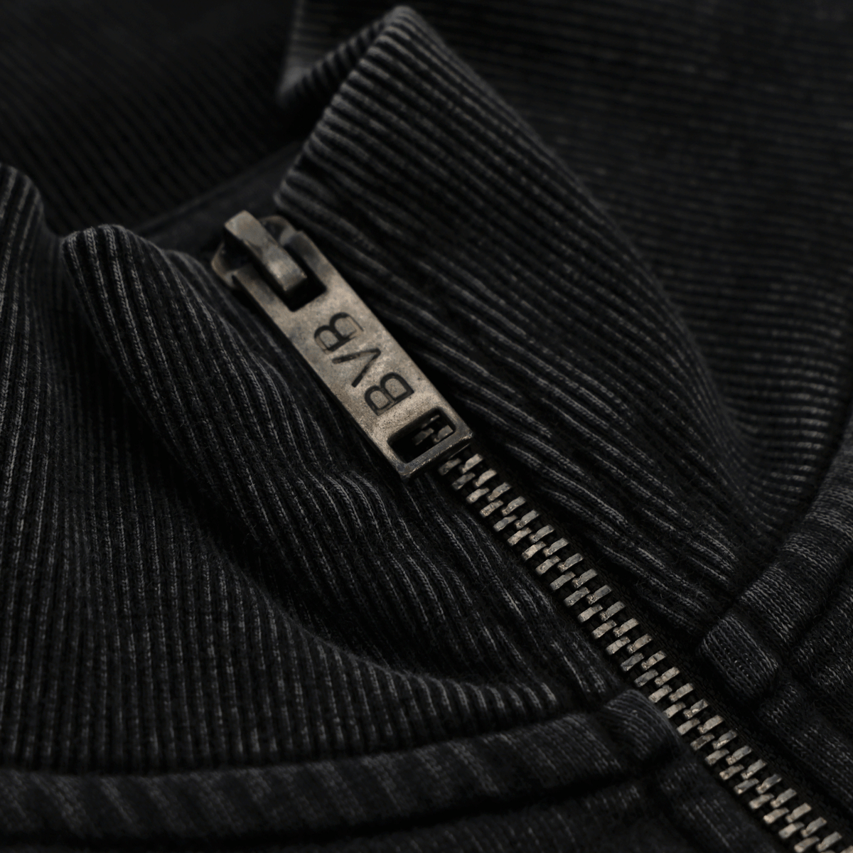 Vue détaillée de la fermeture éclair d'une veste zippée noire du BVB, ornée du logo du BVB gravé.