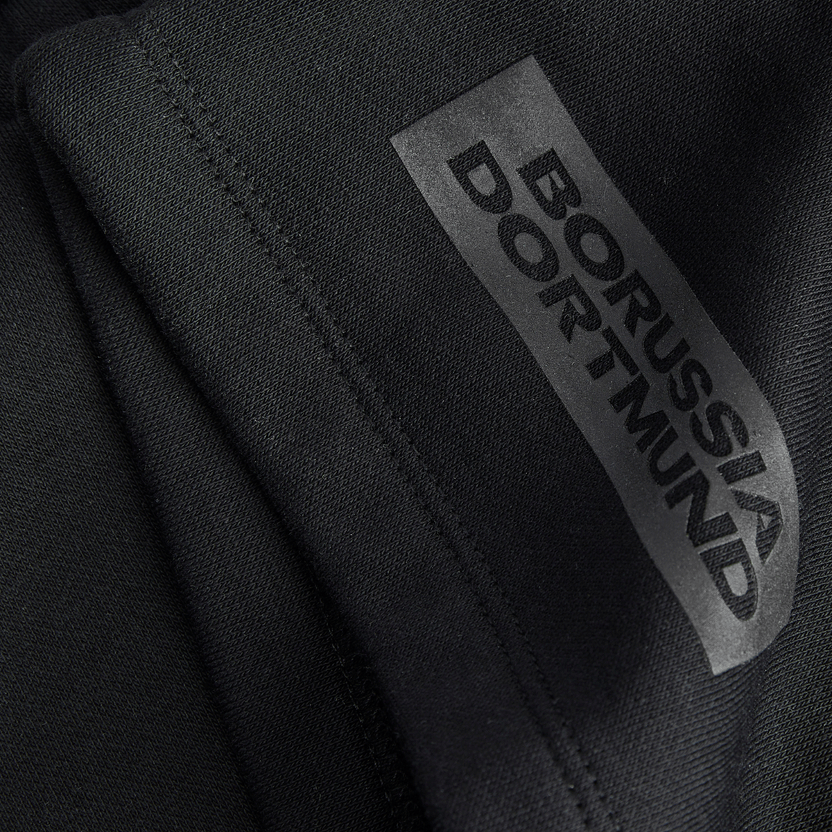 Close-up of the BVB Essentials sweat shorts in black with Borussia Dortmund lettering, ideal for fans and sports enthusiasts.