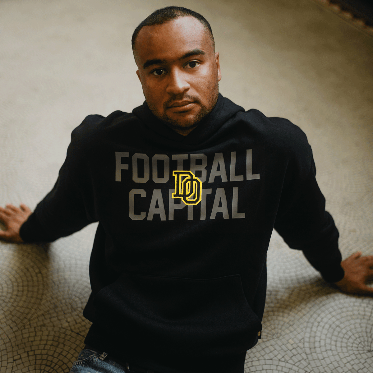 Sudadera con capucha del BVB College en negro y amarillo con el lema «Football Capital», de estilo desenfadado y deportivo, perfecta para los aficionados del BVB.