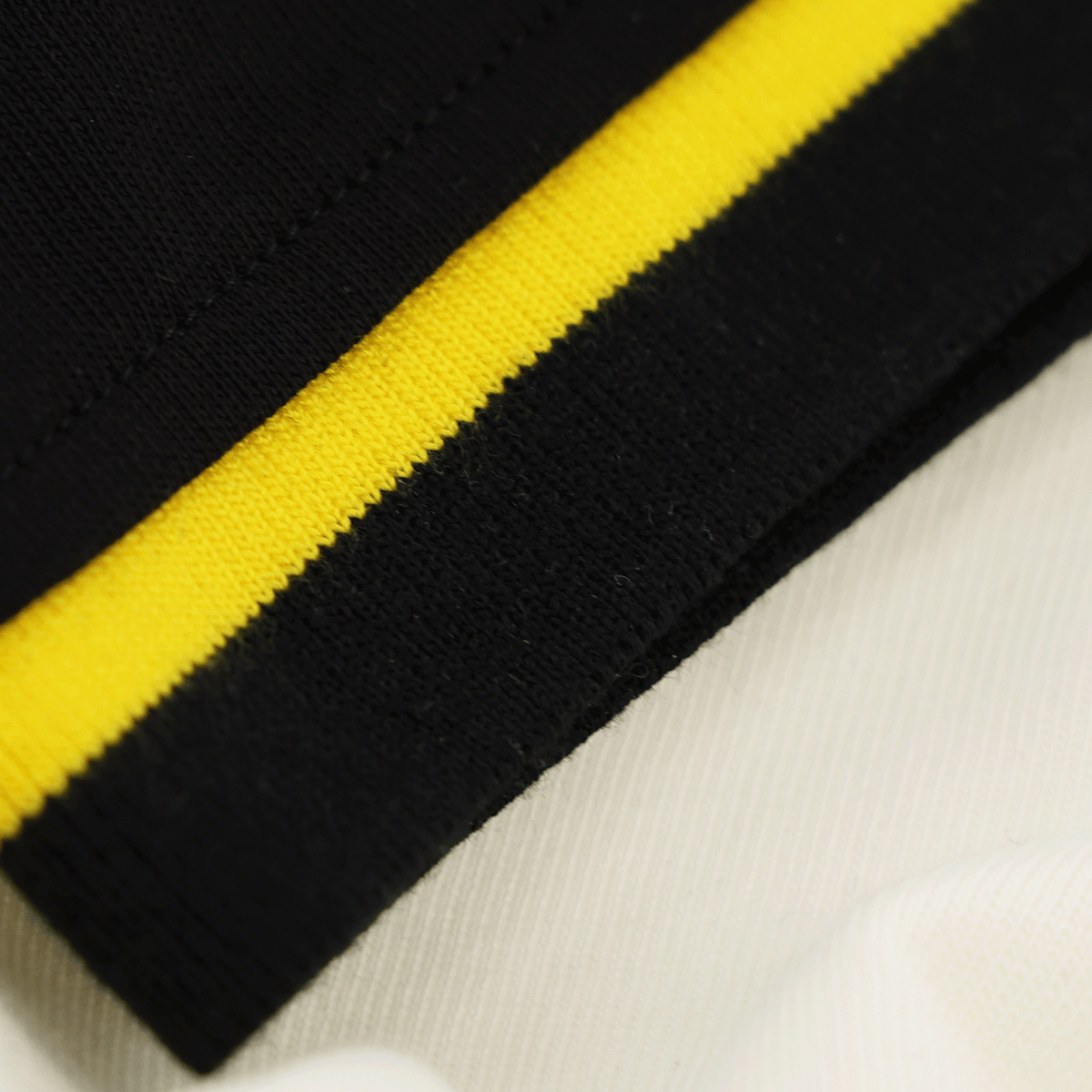 The BVB Iconic Lifestyle T-shirt in off-white with a black-and-yellow striped pattern at the hem—perfect for Borussia Dortmund fans.