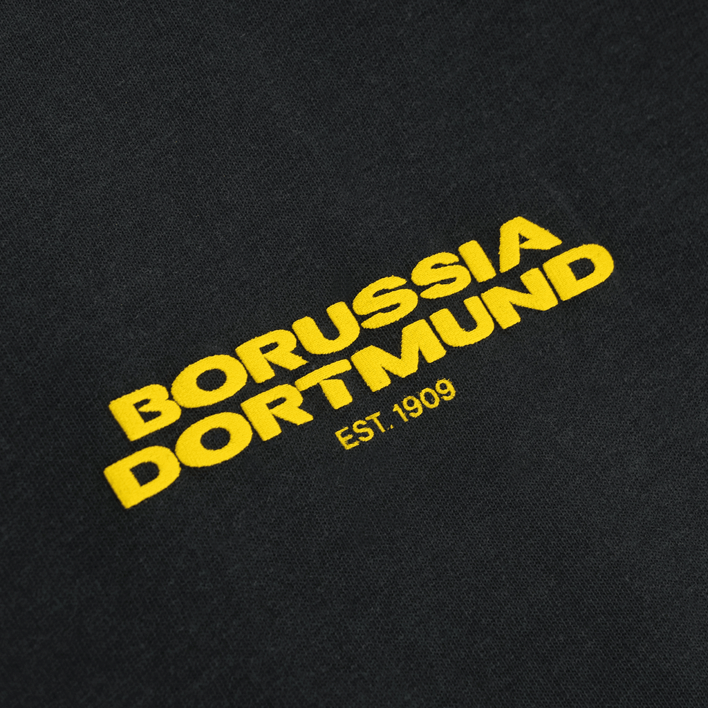 アンтраサイト色のBVBアーバンTシャツ。黄色の「ボルシア・ドルトムント」のロゴと創設年「EST. 1909」が入ったファンアイテム。