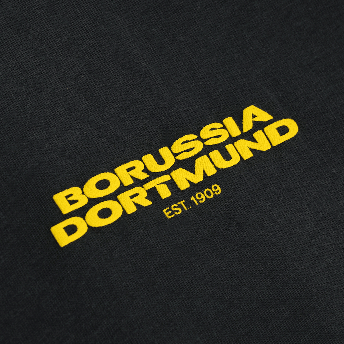 Maglietta BVB Urban color antracite con la scritta “Borussia Dortmund” in giallo e l’anno di fondazione “EST. 1909”, come articolo per i tifosi.