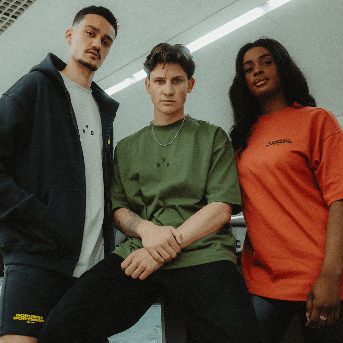 La collezione BVB Urban 2025: modelli nei colori petrolio, verde e rosso, presentati da tre persone con uno stile moderno e disinvolto.
