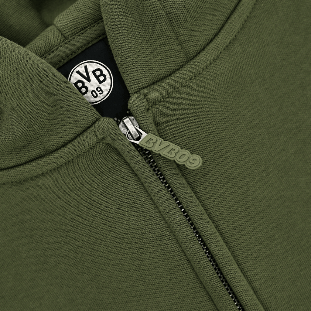 Close-up of a petrol-colored BVB Urban zip jacket with a visible BVB09 logo on the zipper.