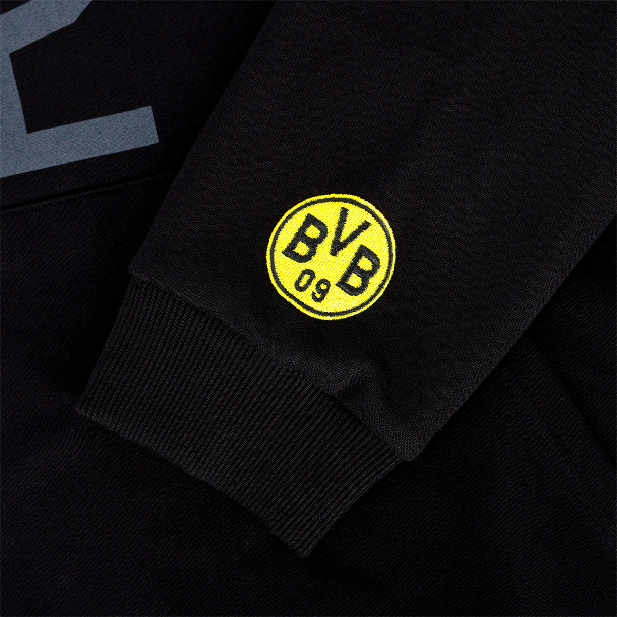 Sweat à capuche noir du BVB issu de la collection International, avec des détails sur les manches et le logo emblématique du BVB 09 en noir et jaune.