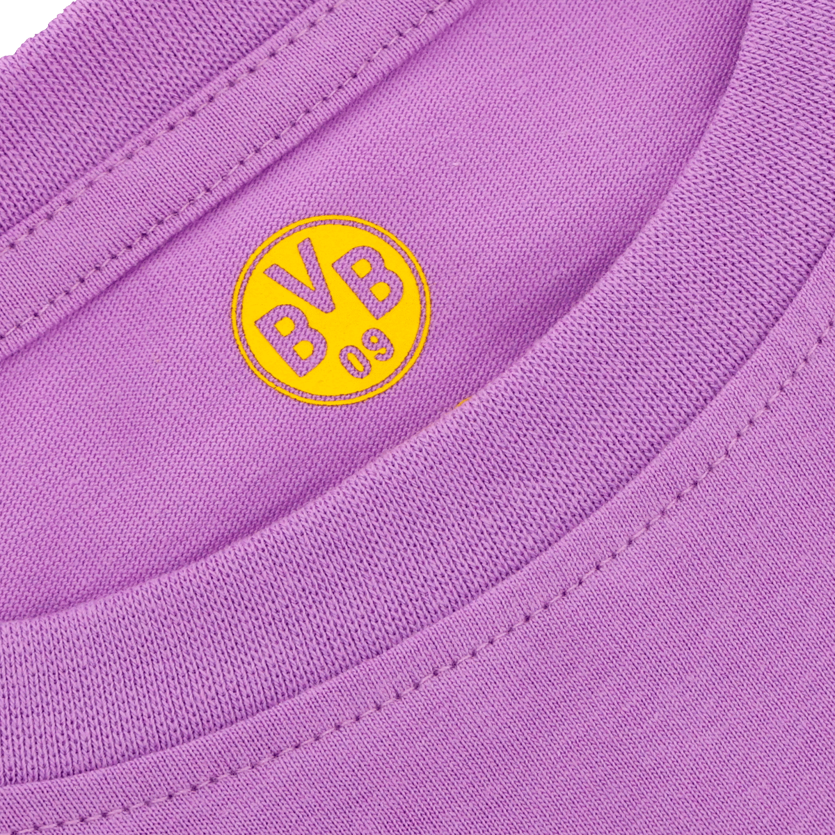 Primer plano de una camiseta infantil del BVB de color lila con el logotipo amarillo del Borussia Dortmund en la nuca.