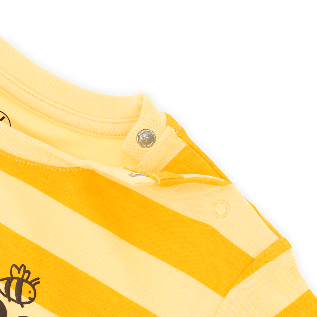 Detailaufnahme eines BVB T-Shirts für Babys und Kleinkinder mit schwarzgelben Streifen, Bienenprint und praktischen Druckknöpfen an der Schulter.