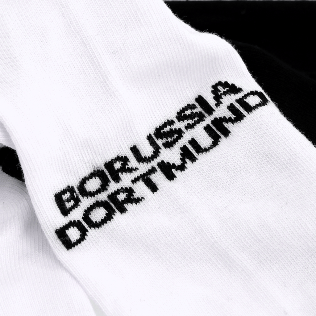 Ein Set aus zwei BVB Sneaker Socken in schwarzweiß mit Borussia Dortmund Schriftzug, ideal für Fans.