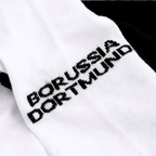 Ein Set aus zwei BVB Sneaker Socken in schwarzweiß mit Borussia Dortmund Schriftzug, ideal für Fans.