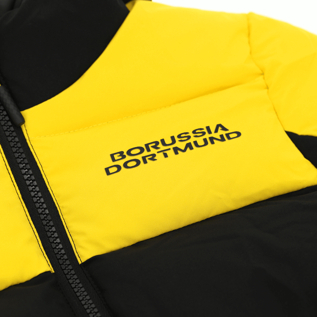 Primo piano della giacca invernale nera e gialla del BVB per bambini con il logo del Borussia Dortmund, ideale per le giornate fredde e per i tifosi.
