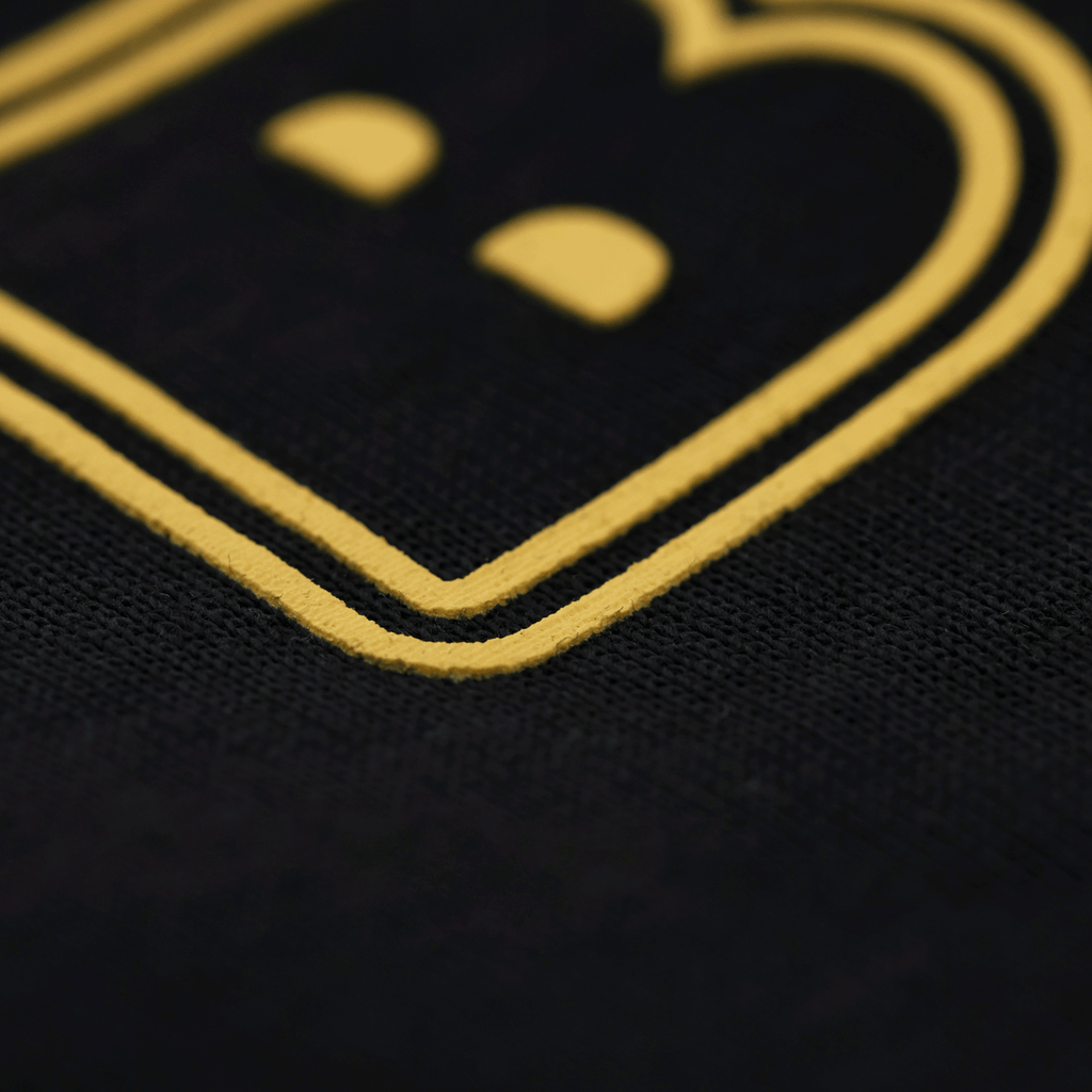 Primo piano del logo su una maglietta nera del BVB con scritta gialla, ideale per i tifosi del Borussia Dortmund.