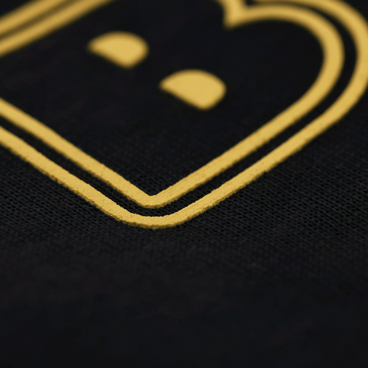 Primo piano del logo su una maglietta nera del BVB con scritta gialla, ideale per i tifosi del Borussia Dortmund.