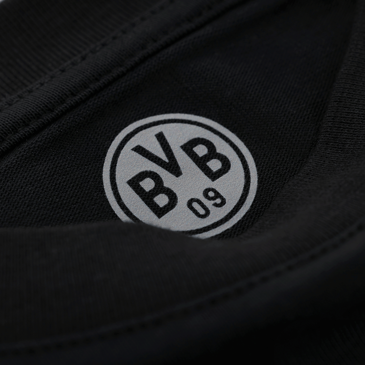 Primo piano della maglietta nera del BVB con il logo BVB 09 ben visibile, ideale per i tifosi del Borussia Dortmund.