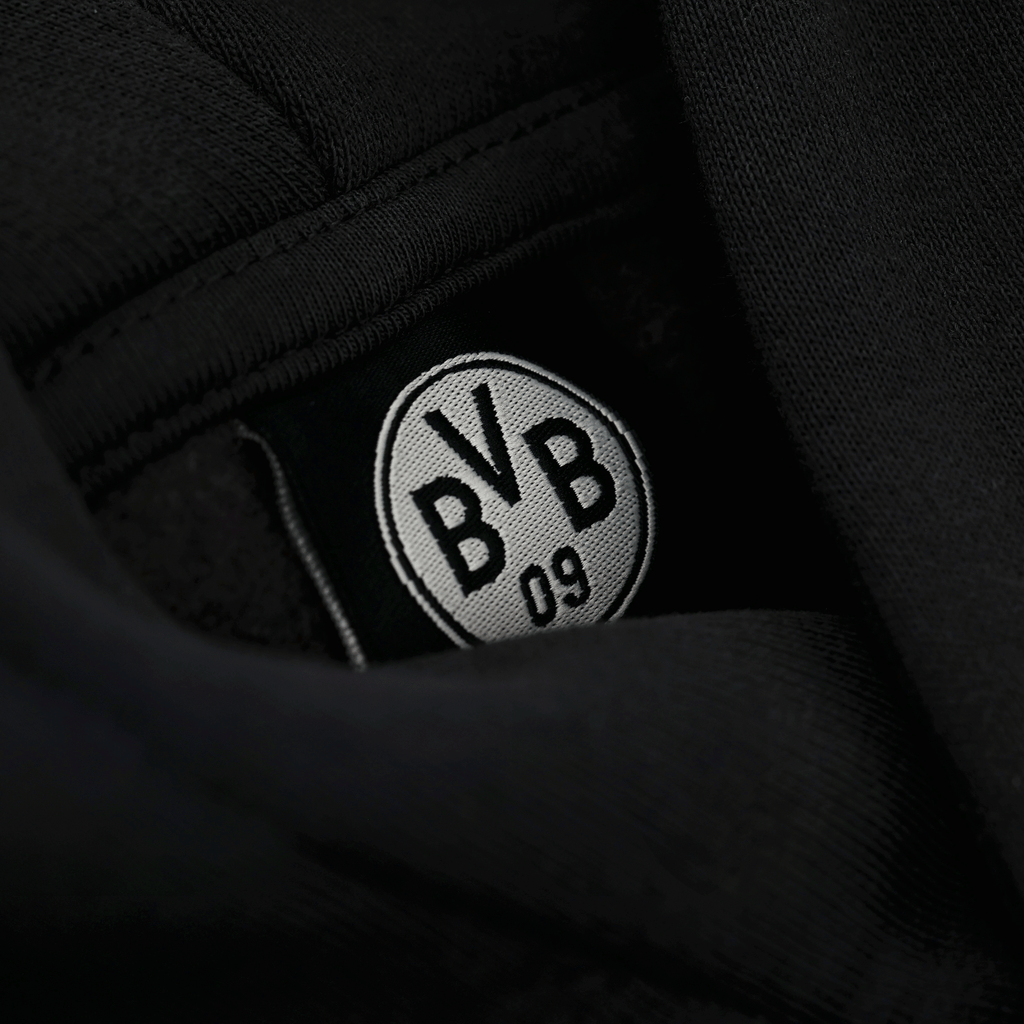 Vue détaillée de l'intérieur d'un sweat à capuche noir du BVB, orné d'un logo BVB 09 brodé en noir et blanc.