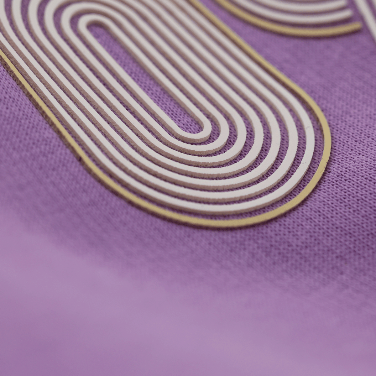 Gros plan sur un sweat à capuche violet du BVB, orné d'un motif graphique accrocheur en blanc et jaune, issu de la gamme de produits officiels du club.