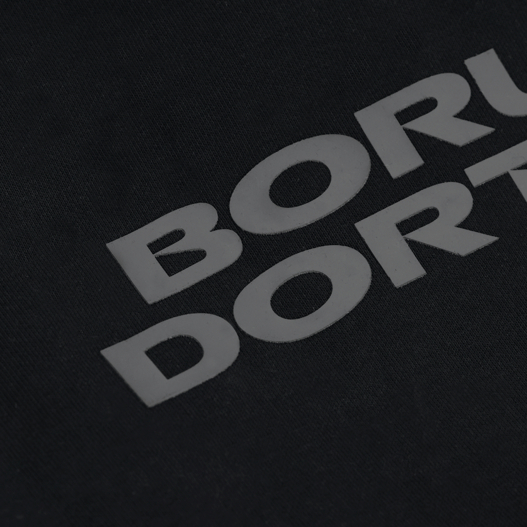 Primo piano della maglietta nera BVB Urban Tee 1909 con la scritta “Borussia Dortmund” in bianco.