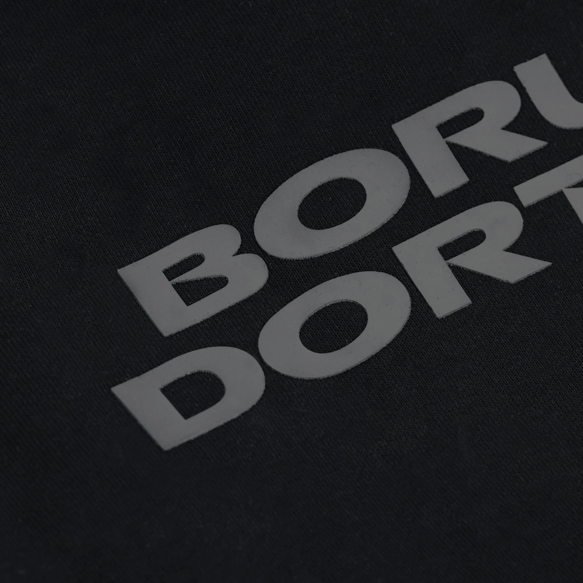 Primo piano della maglietta nera BVB Urban Tee 1909 con la scritta “Borussia Dortmund” in bianco.