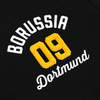 Polo noir BVB Explorer I avec le logo « Borussia 09 Dortmund » brodé en jaune sur le devant.