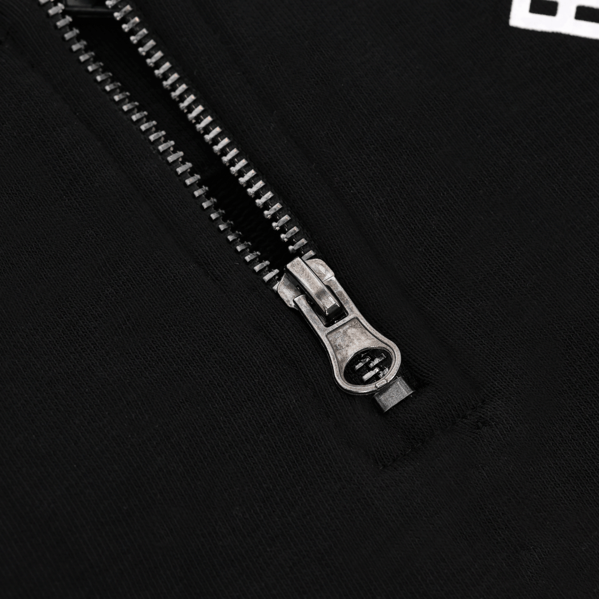Nahaufnahme des Reißverschlusses an einem schwarzen BVB Explorer I Pullover, geeignet als Fanartikel von Borussia Dortmund.