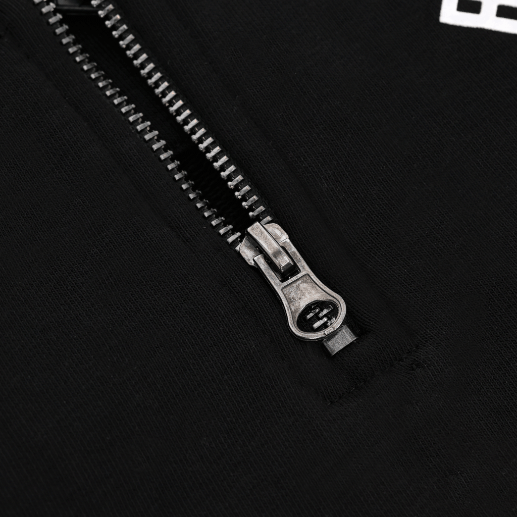 Nahaufnahme des Reißverschlusses an einem schwarzen BVB Explorer I Pullover, geeignet als Fanartikel von Borussia Dortmund.
