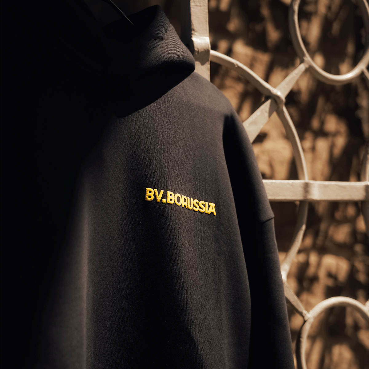Schwarzer BVB-Hoodie Rote Erde mit gelber Stickerei 'BV. Borussia', Fanartikel von Borussia Dortmund.