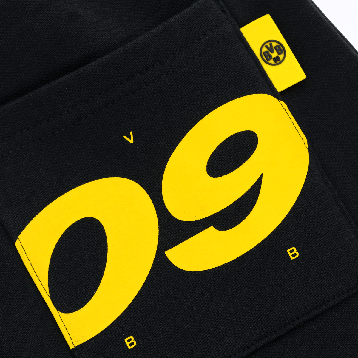 BVB スウェットパンツ「Urban 09」キッズ用（ブラック＆イエロー）のクローズアップ写真。前面のポケットには黄色の「09」デザインとBVBロゴがあしらわれています。