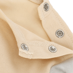 Close-up of a cream-colored BVB jogging set for babies and toddlers, featuring snaps and meticulous craftsmanship.