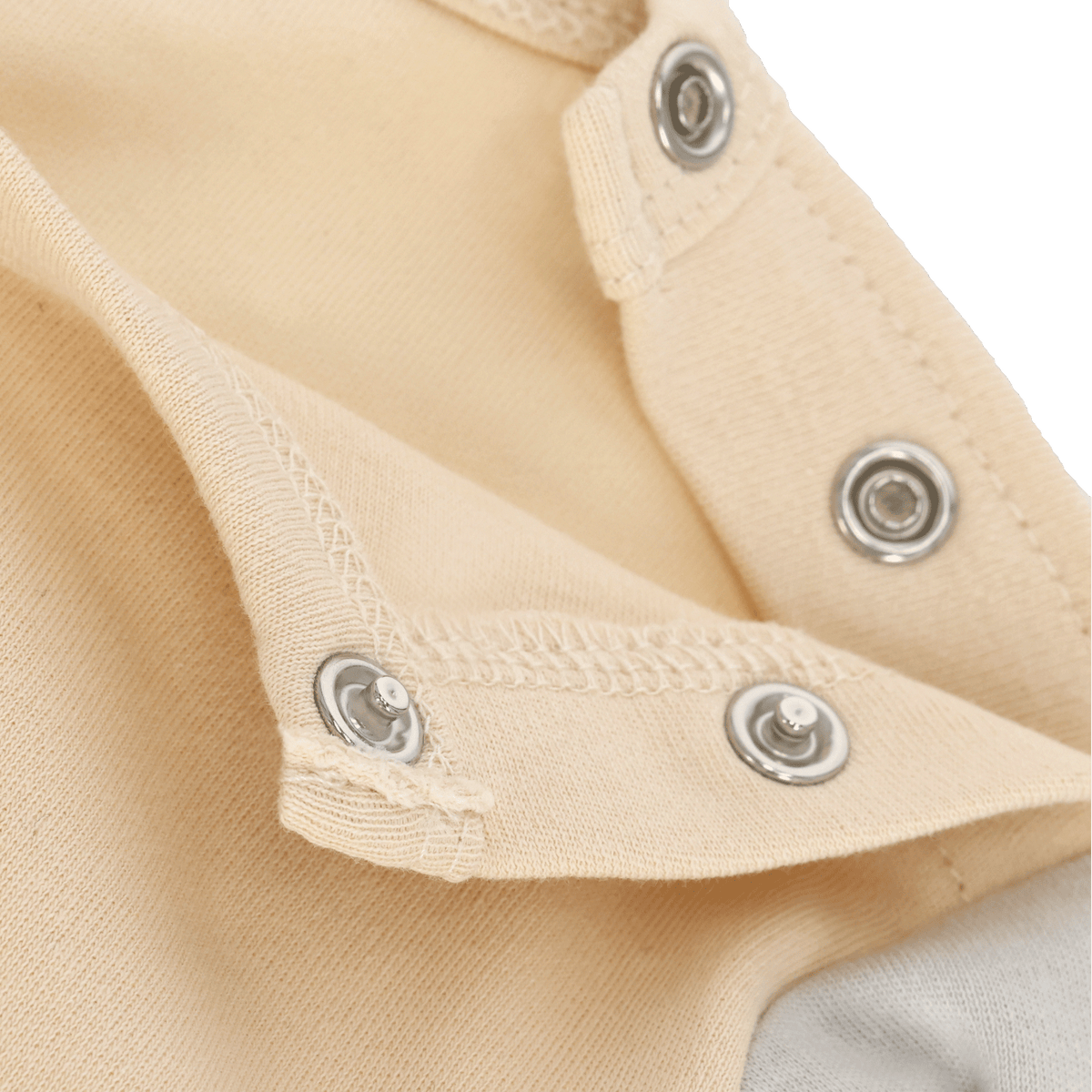 Close-up of a cream-colored BVB jogging set for babies and toddlers, featuring snaps and meticulous craftsmanship.