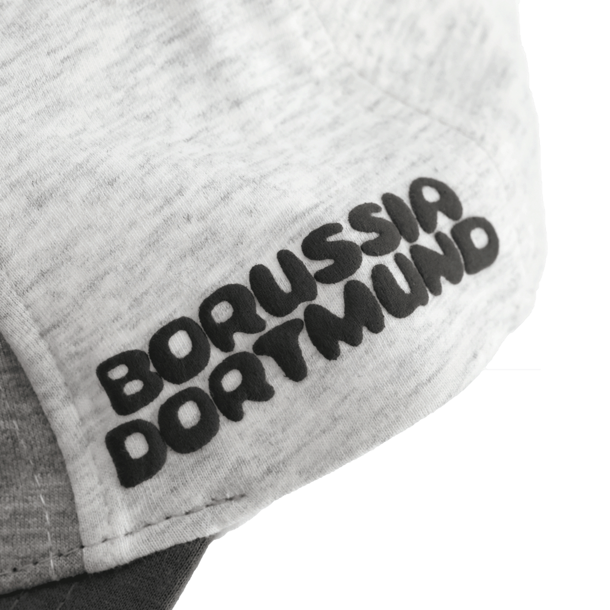 Gros plan sur une casquette pour bébés et jeunes enfants arborant l'inscription « Borussia Dortmund » en noir et jaune et présentant un design « color block ».
