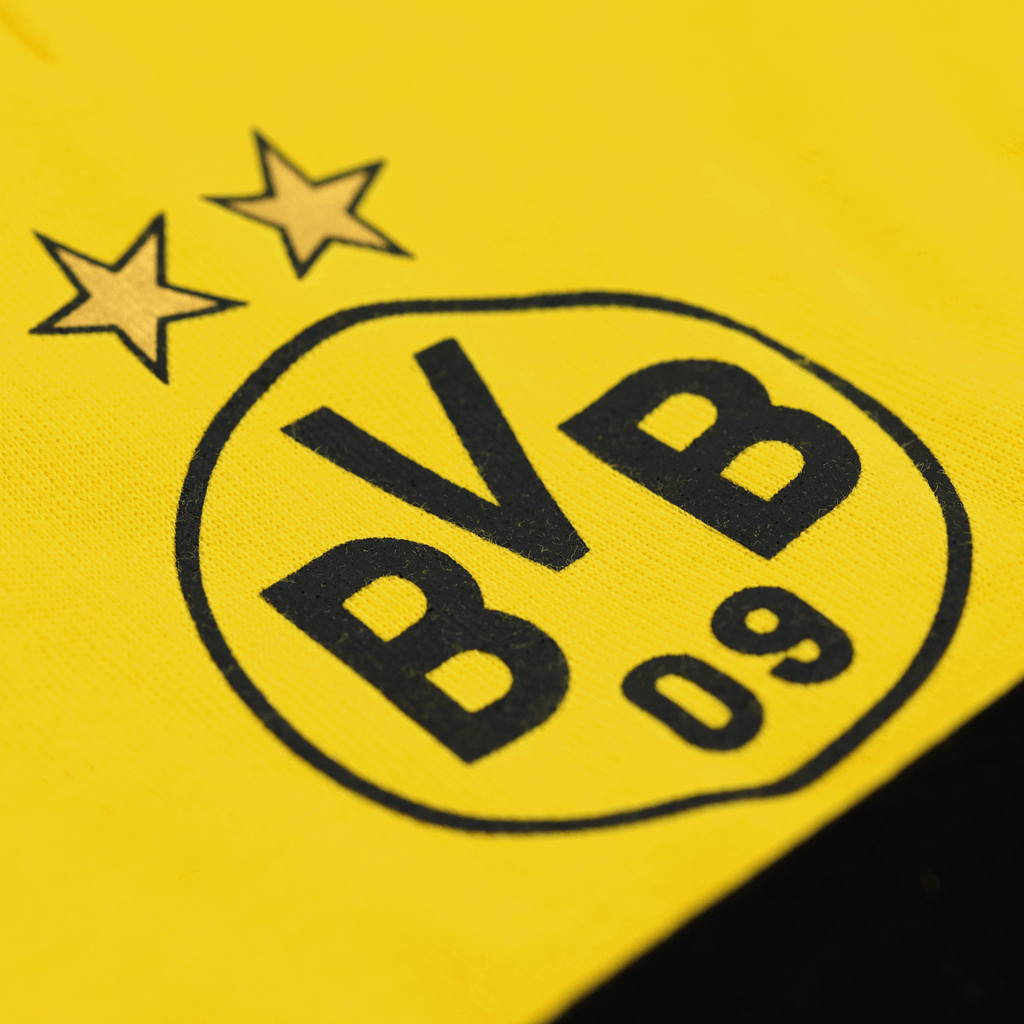 Close-up of the BVB emblem with two stars on yellow fabric, part of a BVB baby gift box.