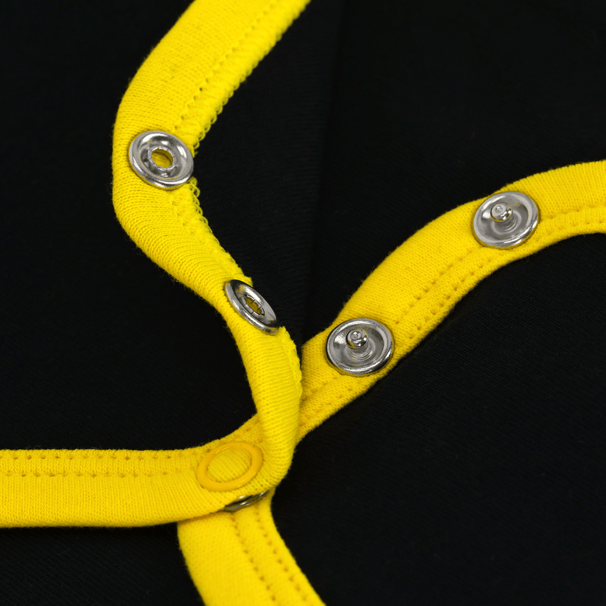 Gros plan sur un body pour bébé du BVB aux couleurs noir et jaune, doté de boutons-pression pratiques et de l'emblème du BVB.