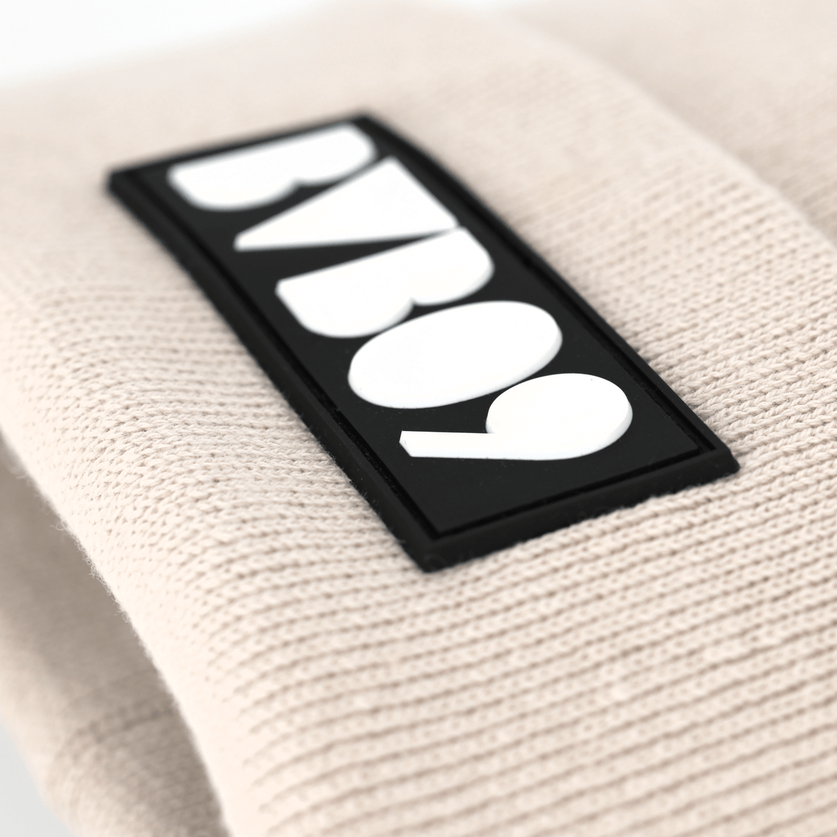 Beige BVB-Mütze mit prominentem BVB 09-Logo in Schwarz und Weiß, ideal für Fans von Borussia Dortmund.