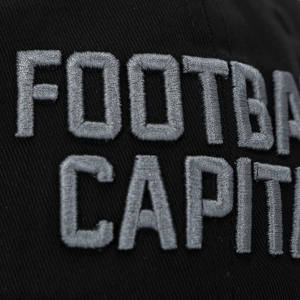 Close-up of a black BVB New Era 9Twenty College children's cap with eye-catching white "FOOTBALL CAPITAL" lettering.