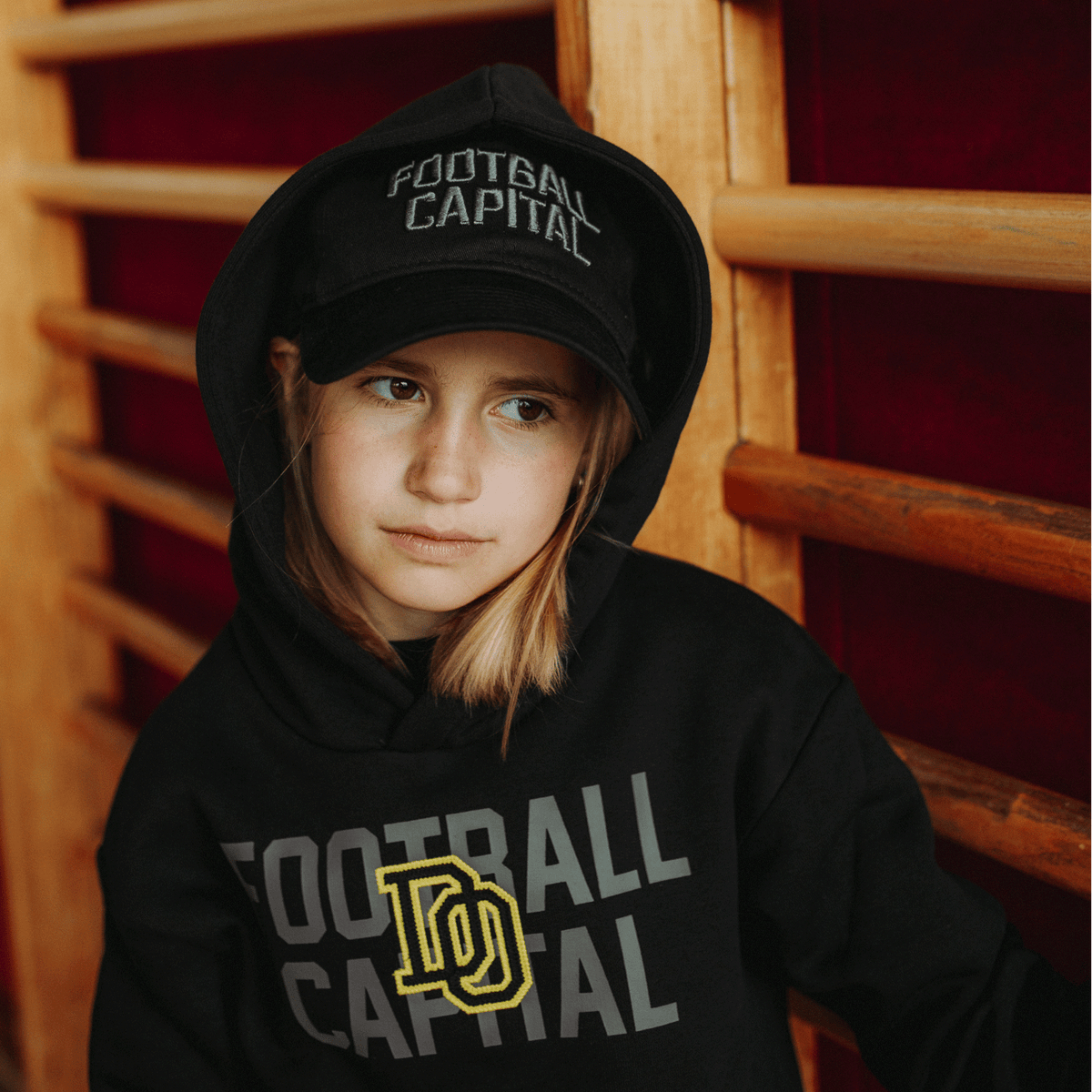 Black BVB New Era 9Twenty College cap for kids, worn by a child, perfect for young Borussia Dortmund fans.